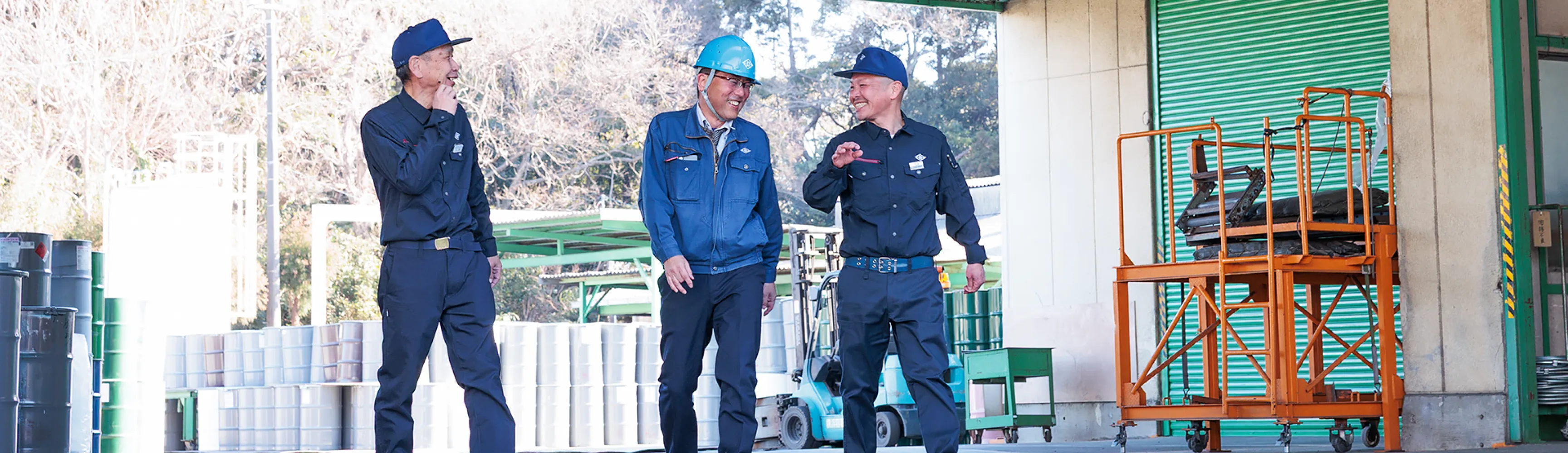 工場内で談笑する男性3人